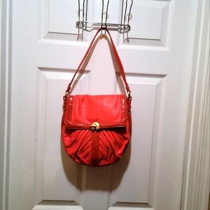 Perlina poppy leather with patent trim shoulder handbag.